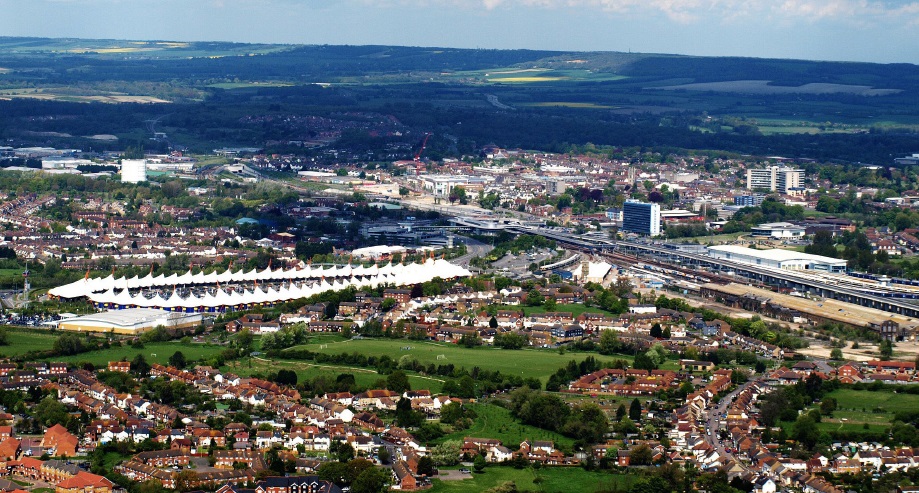 A twilight photograph captures the Southend Pier Head complex, showcasing the dramatic, modern, glass-fronted Southend Pier Cultural Centre (or Pier Head building) illuminated from within, standing over the water at the end of a wooden pier structure, with the older pier infrastructure and dark, cloudy sky framing the scene.