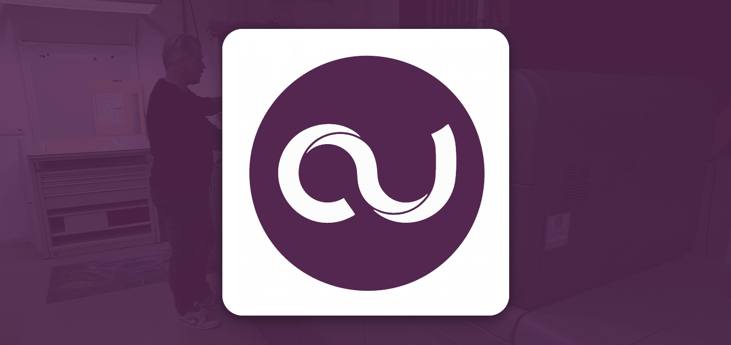 Cards Unlimited logo - Man operating a Ricoh printer in a dimly lit room. The scene is overlaid with a purple tint, and a white logo featuring a stylized 