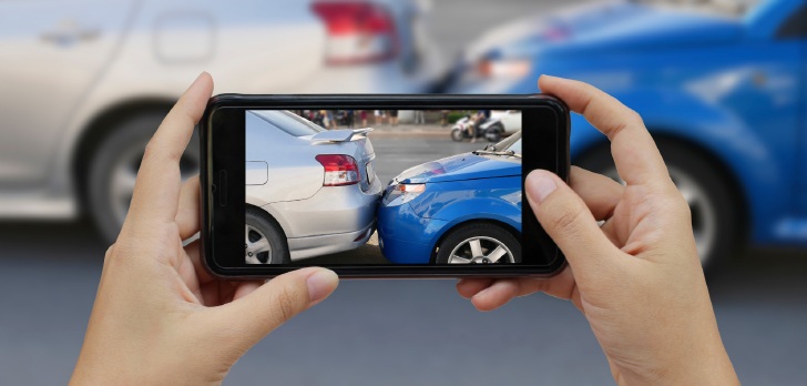 Smartphone capturing a minor car collision, supporting fast, accurate and digital insurance claim processes.