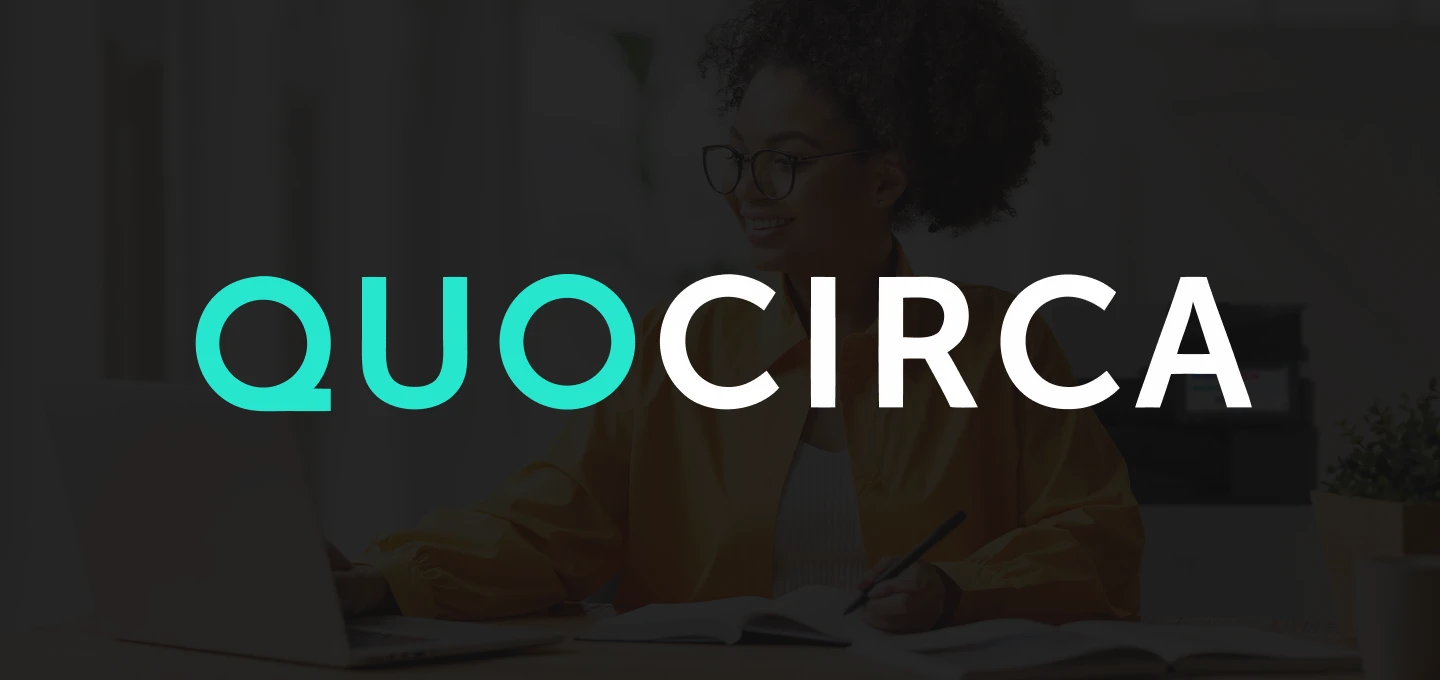 QUOCIRCA logo over a dark background showing a person working at a desk with a laptop, notebook and multifunctional printer on the background.