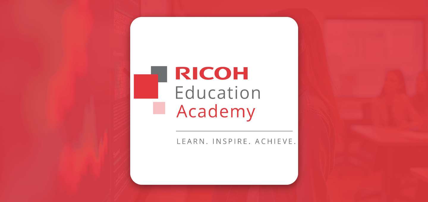 Ricoh Education Academy logo displayed on a white card against a red-tinted classroom background, featuring the text “RICOH Education Academy” and the tagline “Learn. Inspire. Achieve”