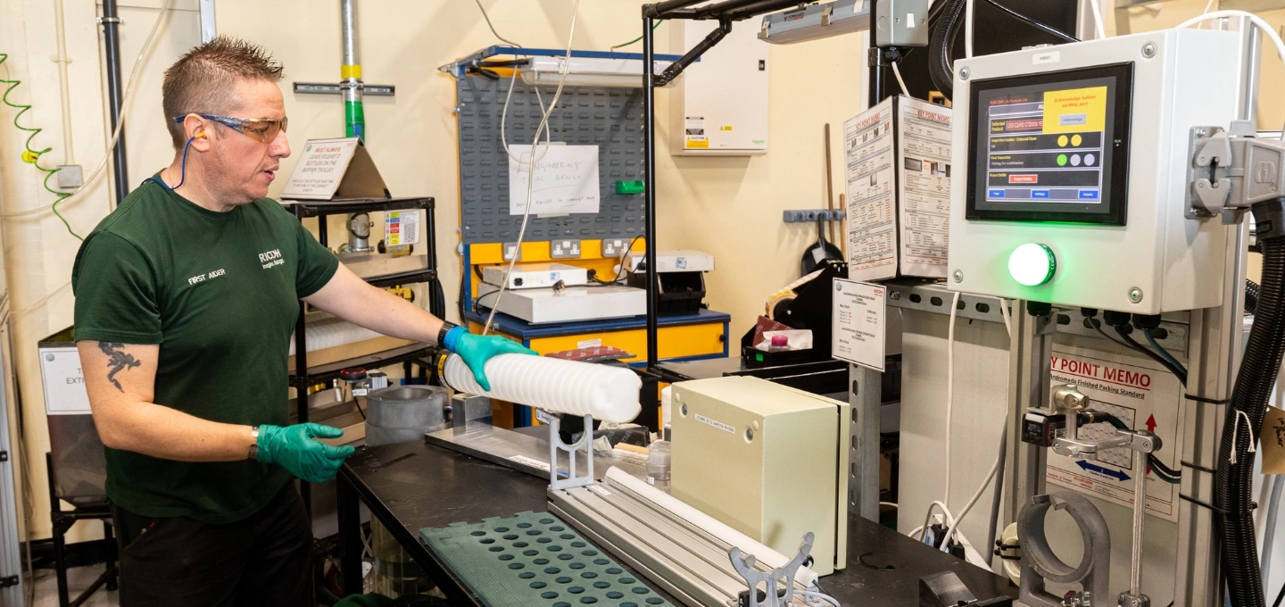 A Ricoh employee utilising 3D-printed apparatus on the production line.