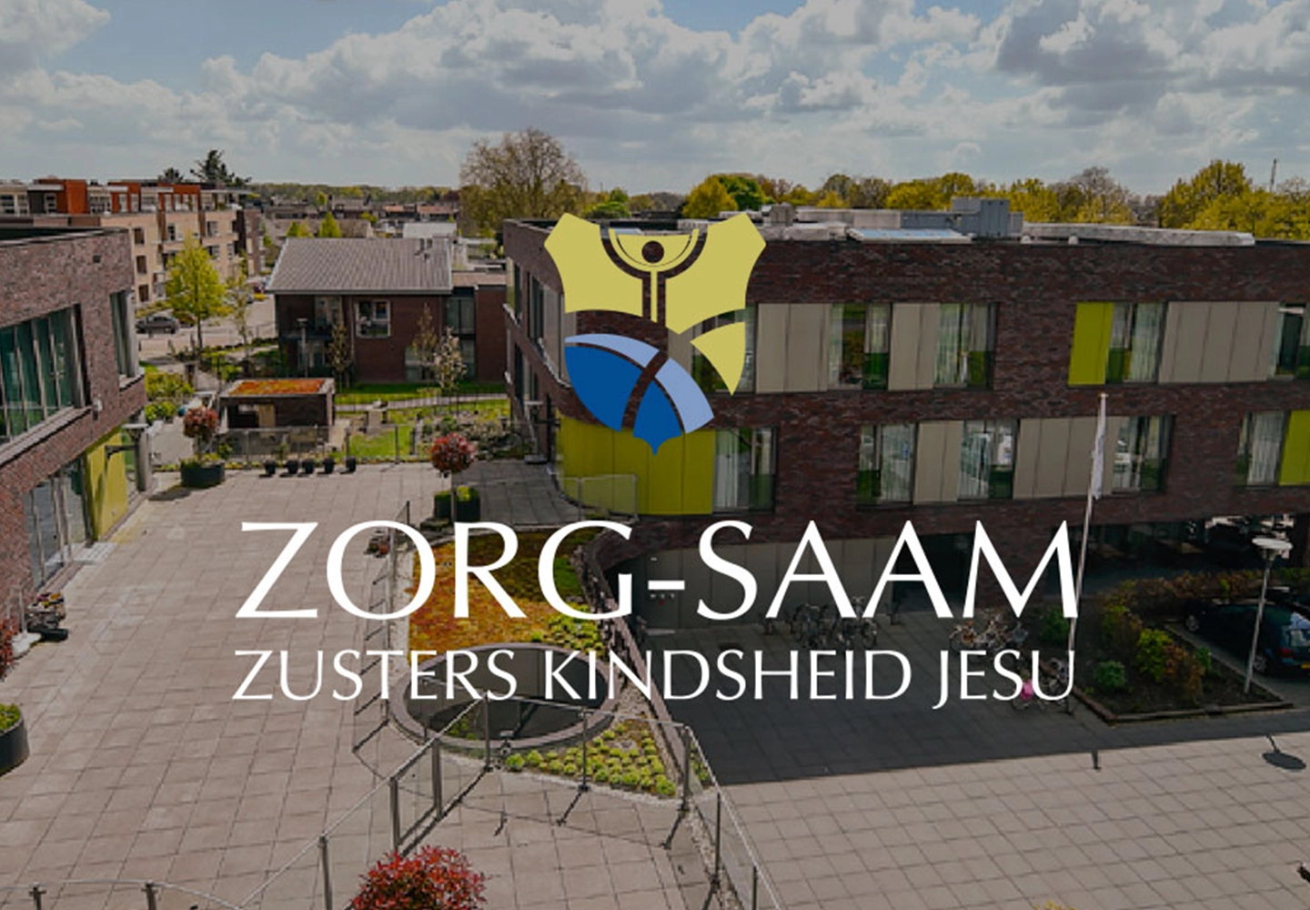 Overhead view of a modern building complex with brick walls, large windows, and surrounding greenery. The logo and text "Zorg-Saam Zusters Kindheid Jesu" overlayed in the center. The atmosphere is calm and inviting.